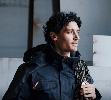 Professional workers wearing branded workwear in industrial setting with safety helmets